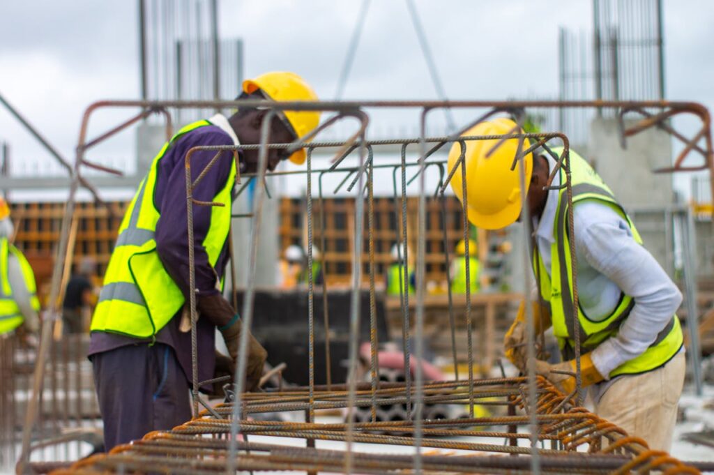 pexels photo 10202856 Construction workers with hard hats and safety vests working on site.