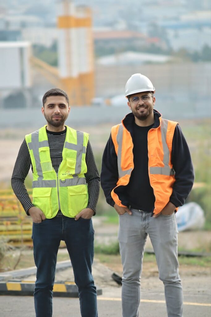 pexels photo 34670930 Two construction workers in safety gear at an outdoor site, showcasing teamwork.